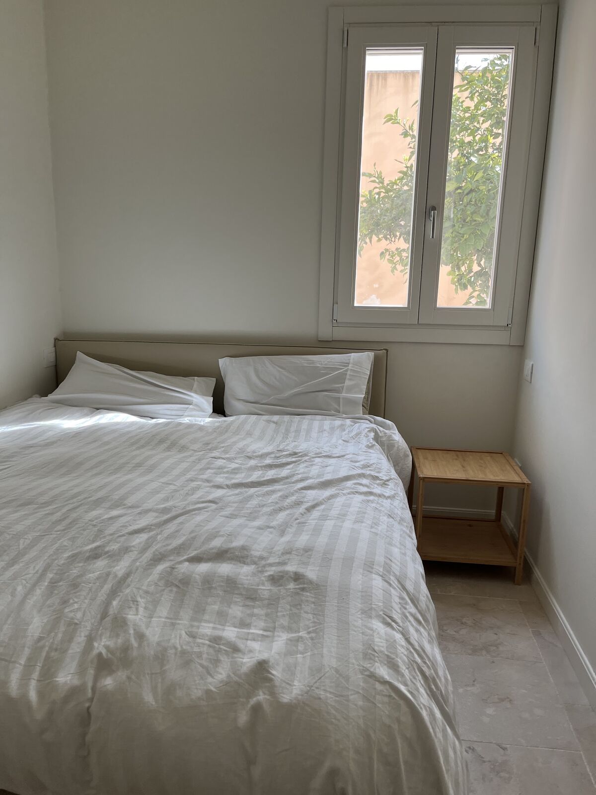 Calm white bedroom with garden light